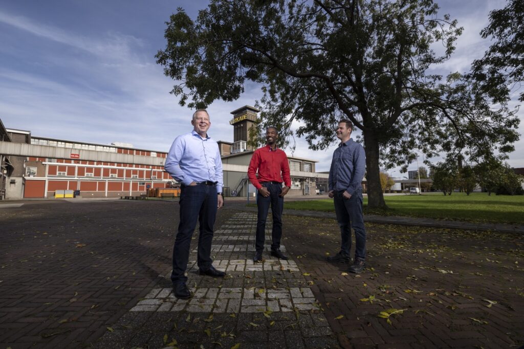 Drie projectmanagers staan voor het gebouw van Verkade in Zaandam