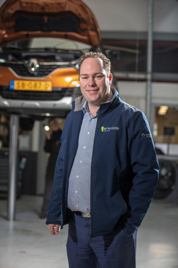 Eigenaar van Renault autobedrijf in Hardenberg poseert voor hefbrug