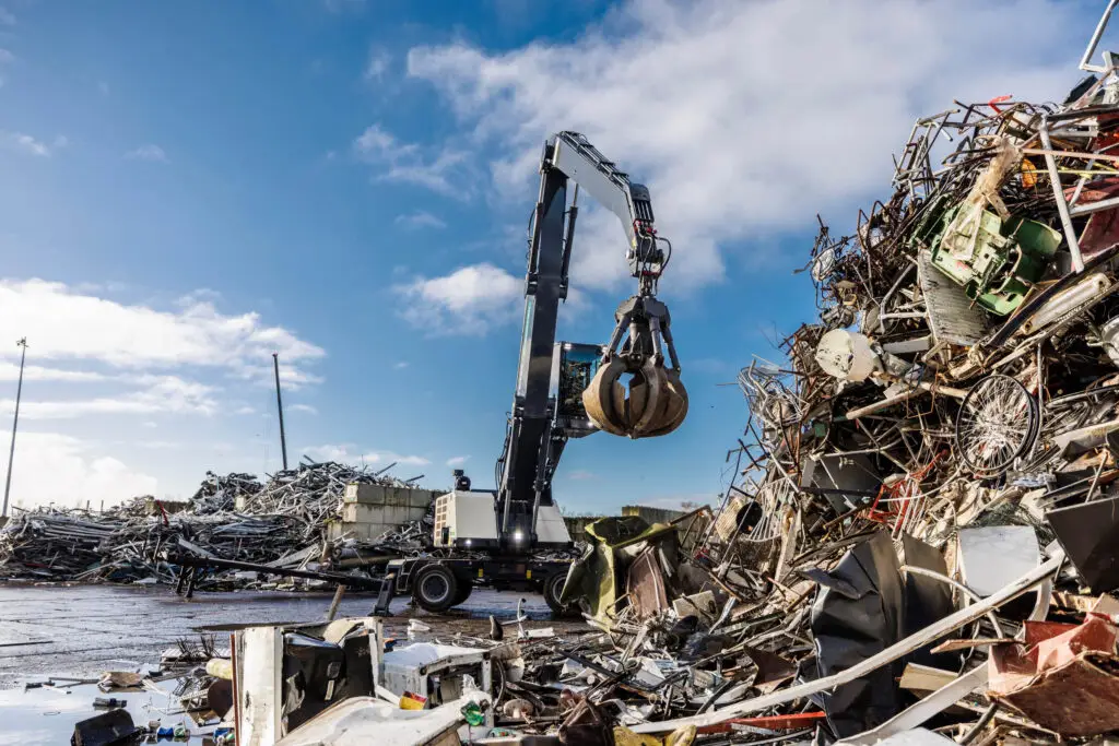 Machine verwerkt metaal op een recyclingterrein