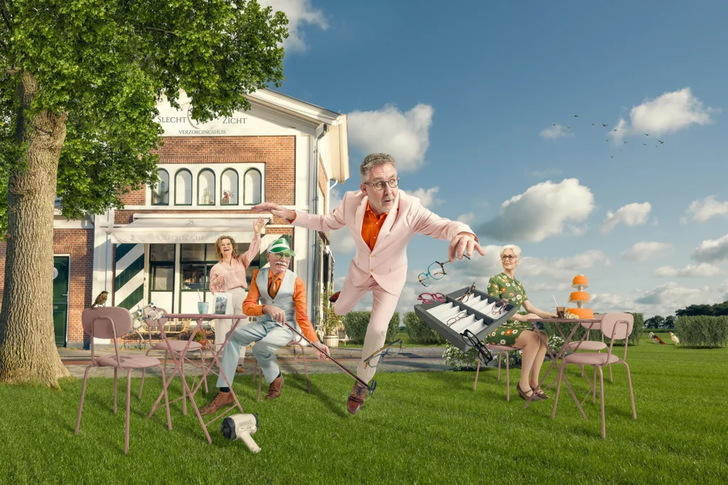 Een man in een roze pak struikelt over een wandelstok