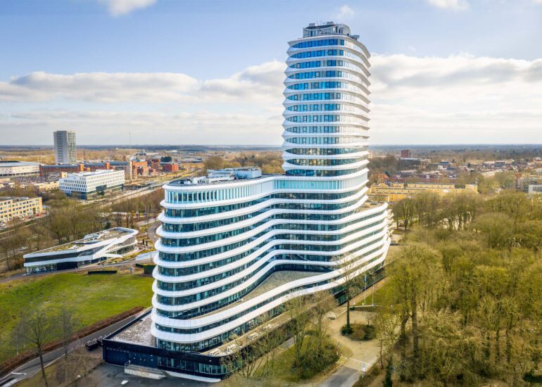 Luchtfoto van het witte DUO-kantoor met gebogen gevel in Groningen