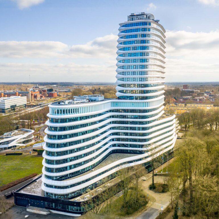 Luchtfoto van het witte DUO-kantoor met gebogen gevel in Groningen