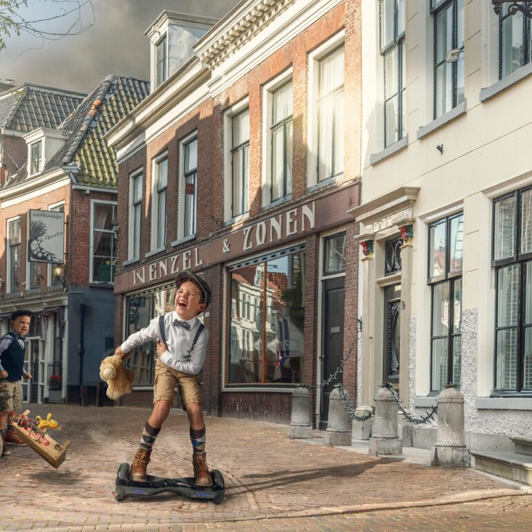 Geënsceneerde foto van twee jongens in een historische straat, met speelgoed en een hoverboard