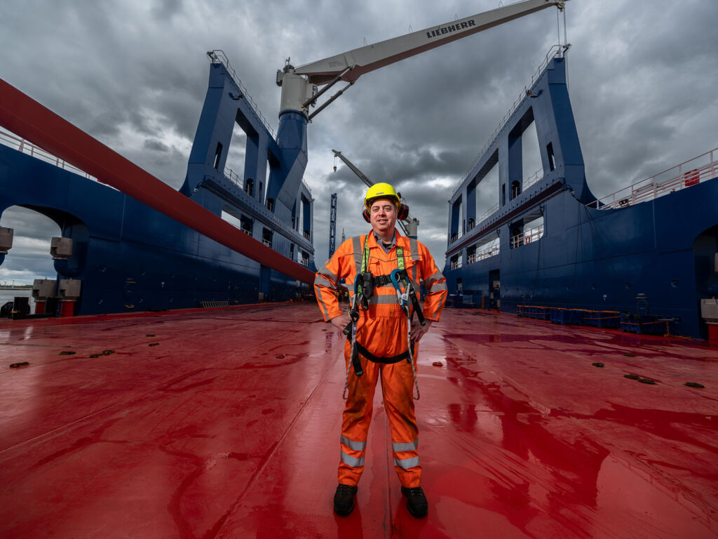kapitein van het schip, de Rotra Futura van rederij Amasus, staat in oranje overall centraal op dek
