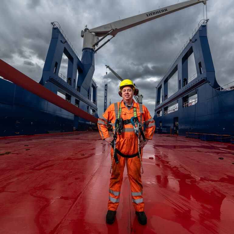kapitein van het schip, de Rotra Futura van rederij Amasus, staat in oranje overall centraal op dek