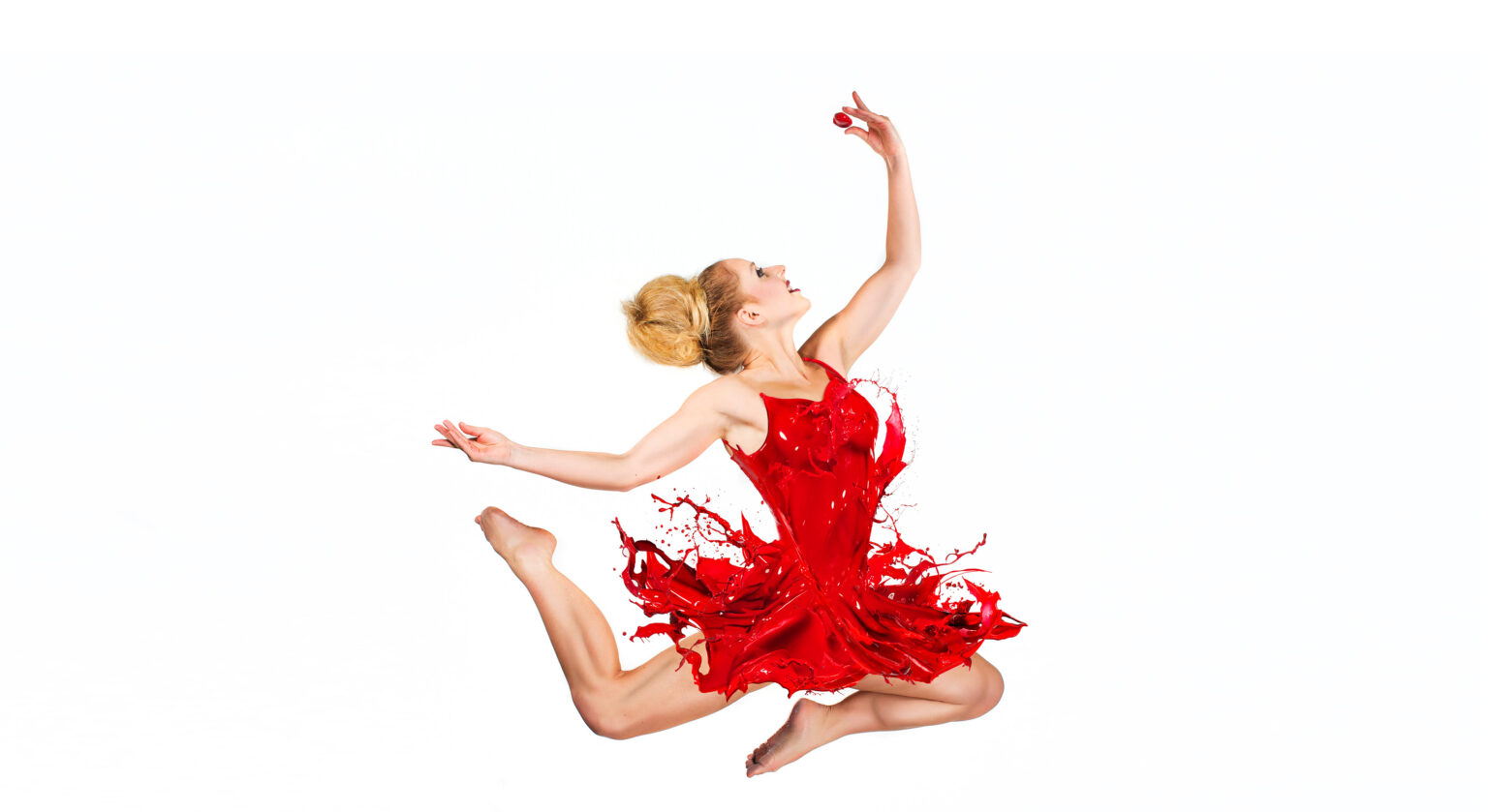 Springende danseres met een jurk van rode verf tegen een witte achtergrond