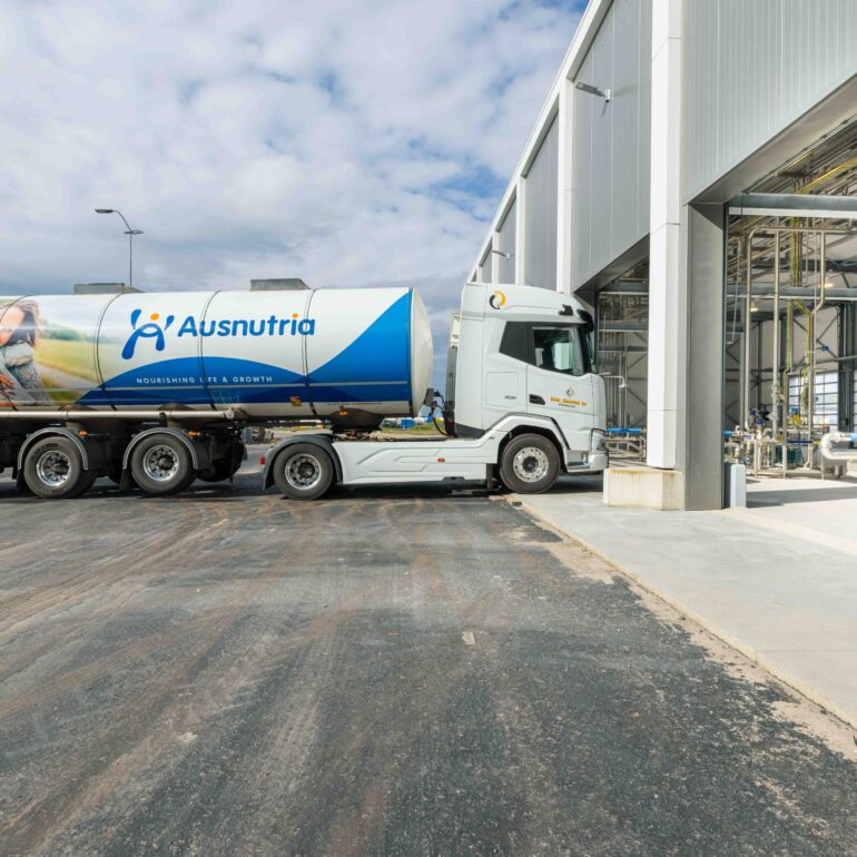 Tankwagen met Ausnutria-logo bij een fabrieksgebouw.