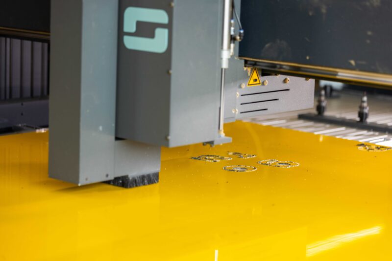 Productiemachine bewerkt een geel paneel bij Panelvision.
