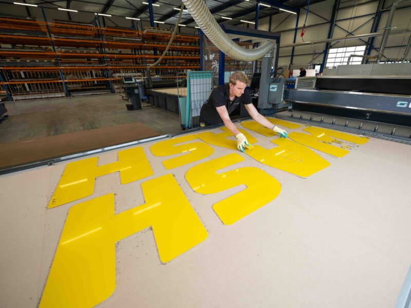Panelvision-medewerker haalt gele onderdelen van een werktafel.