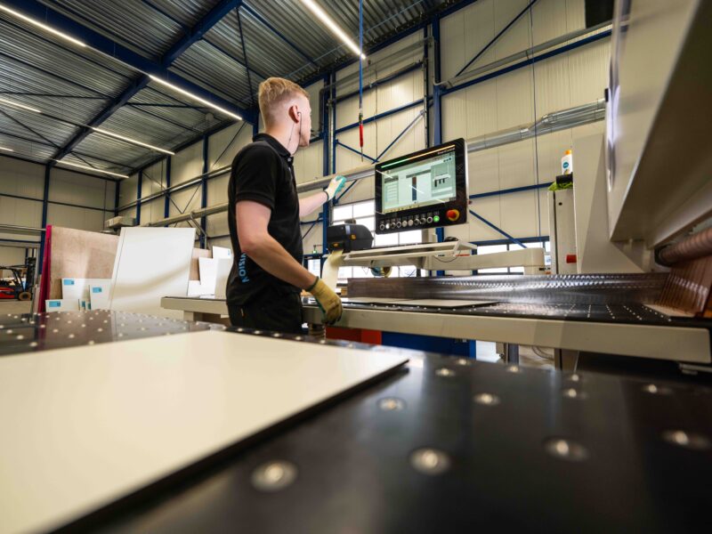 Panelvision-medewerker bedient het scherm van een productiemachine in de werkplaats.